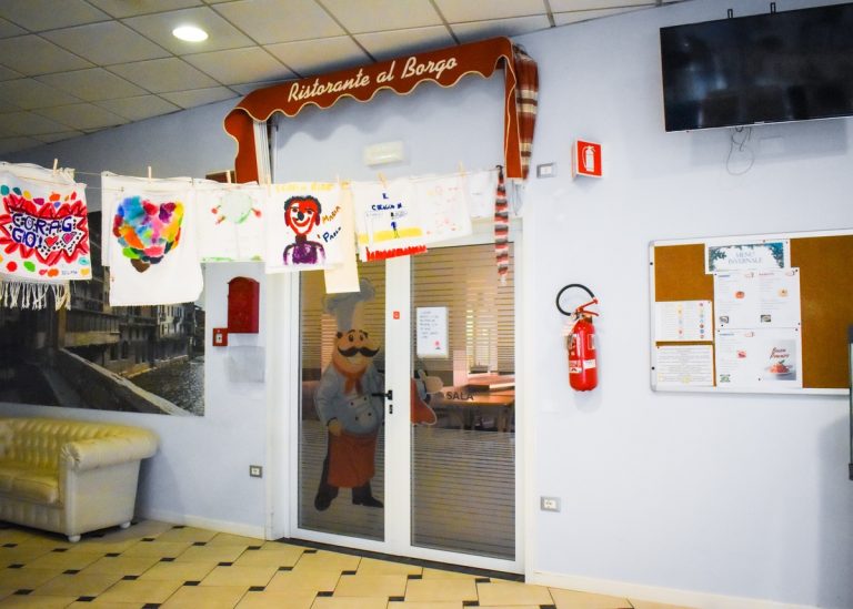 Ingresso del "Ristorante al Borgo" con decorazioni e bacheca