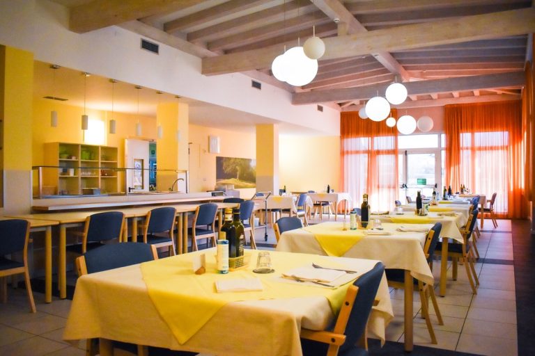 Sala da pranzo luminosa con tavoli apparecchiati
